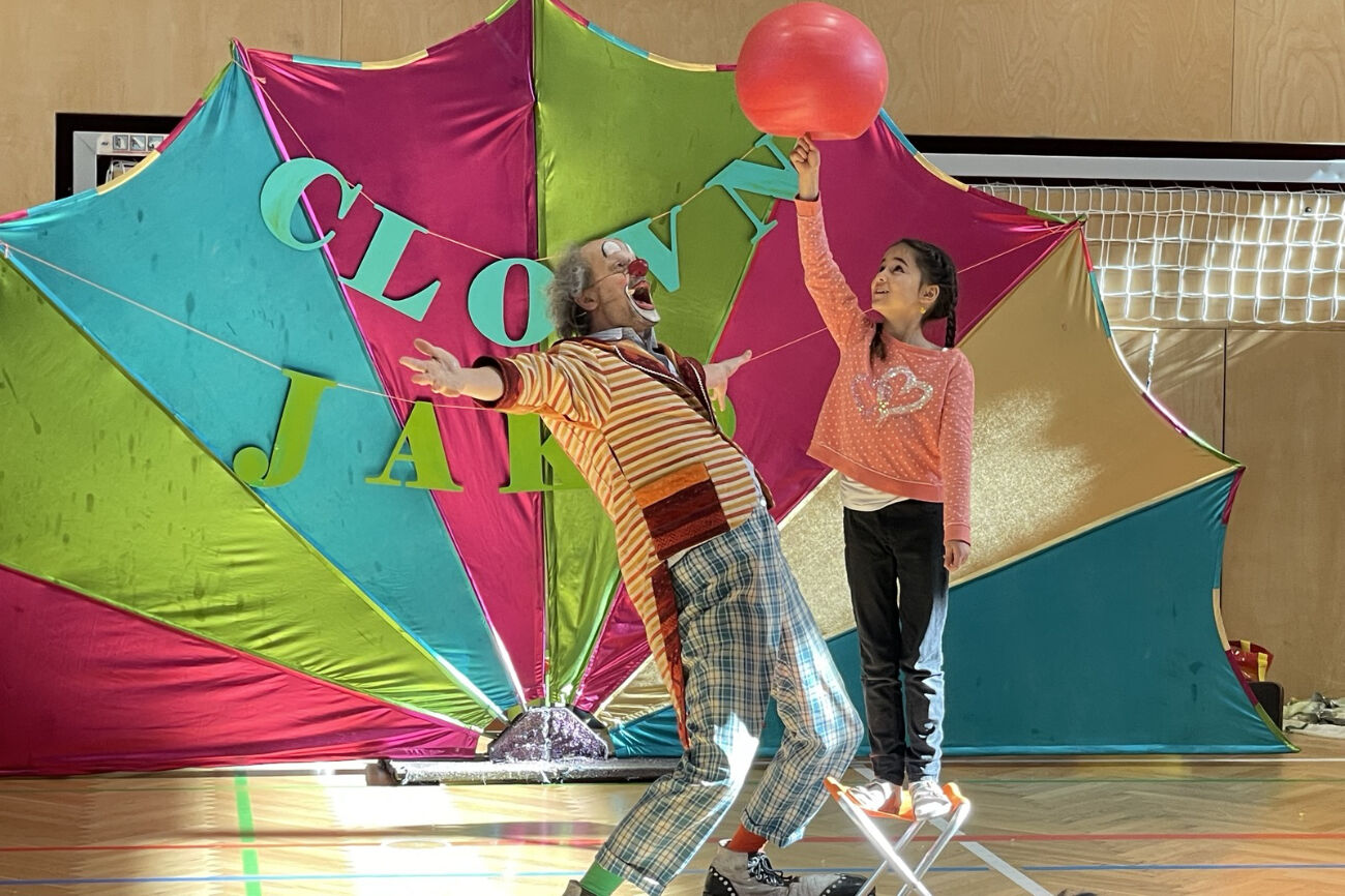 Zwei Buben probieren über ein Holzhindernis am Eis zu springen.