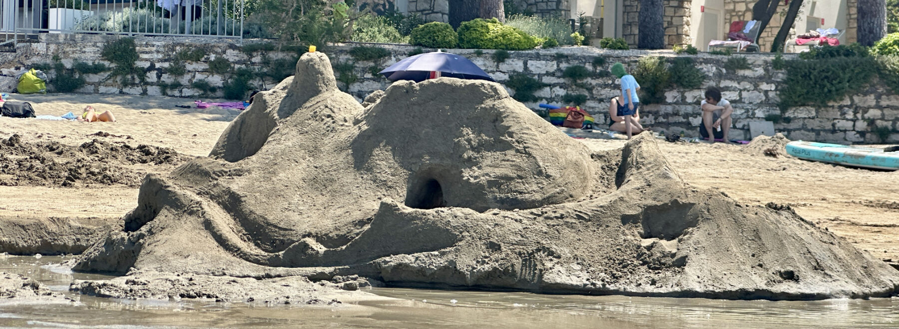 Eine Sandburg am Meer mit einem Tunnel.