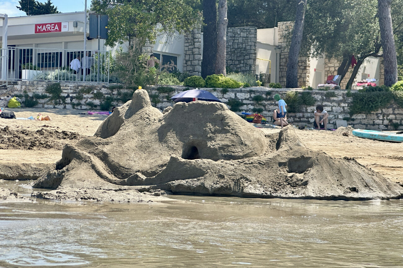 Eine Sandburg am Meer mit einem Tunnel.