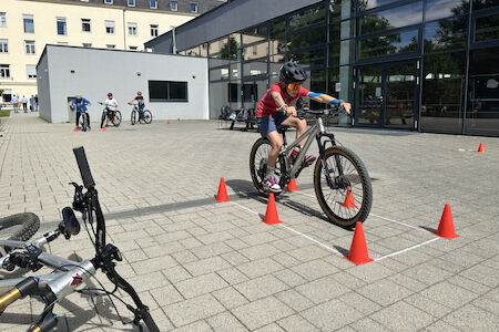Kind macht mit einem MTB eine exakte Zielbremsung zwischen Hütchen.