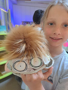 Ein Kind hält die Eierkartonhandpuppe.