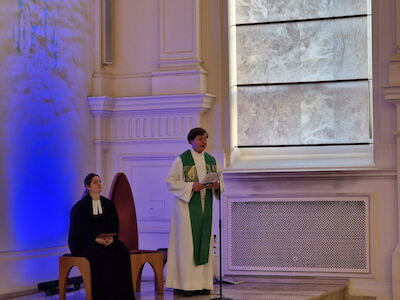 Dr. Lukas Weissensteiner spricht vom Altar zu den Kindern.