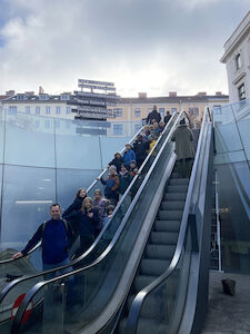 Die Fuchs-Klasse fährt mit der Rolltreppe zum Eingang des Naturkundemuseums hinunter.