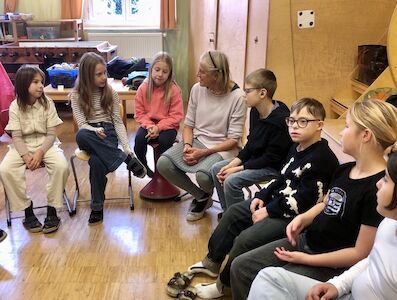 Frau Stenzel arbeitet mit den Kindern im Sitzkreis zum Thema "Jeux Dramatiques".