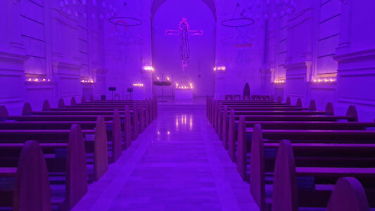 Stimmungsvolle Atmosphäre in der Kirche des Augustinums ohne Menschen und vielen brennenden Kerzen (Querformat).