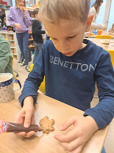 Ein Bub verziert einen Lebkuchen.