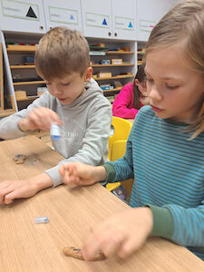 Zwei Kinder verzieren ihren Lebkuchen in der Klasse.