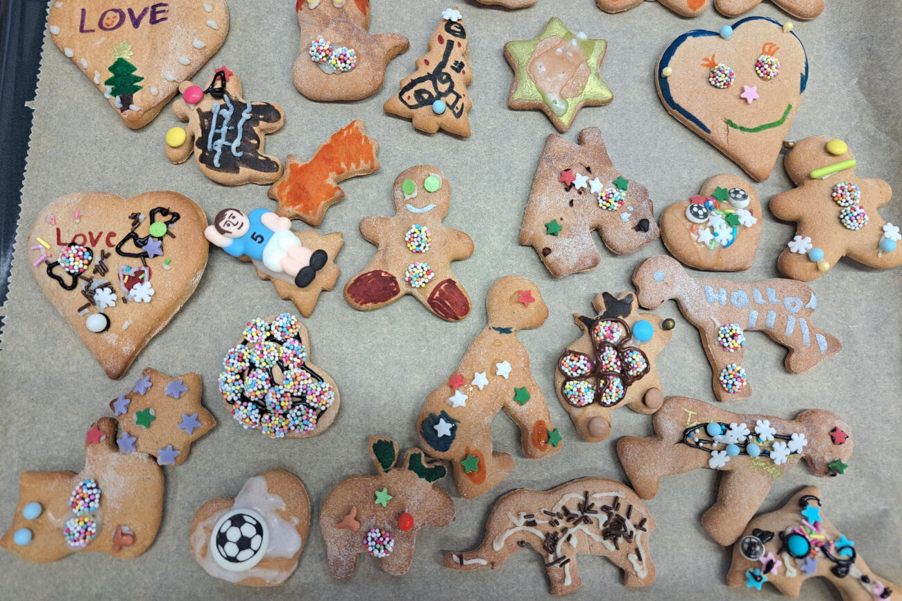 Weihnachtslebkuchen liegen auf einem Backblech und wurden reich verziert.