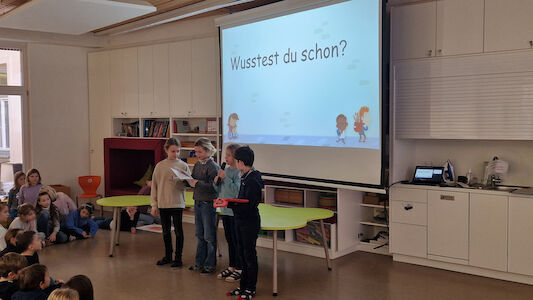 Vier Kinder stellen der Schulgemeinschaft 5 wichtige UK-Begriffe vor.