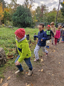 Fröhlich spazieren einige Kinder bei bedecktem Wetter in der natur.werk.stadt umher.