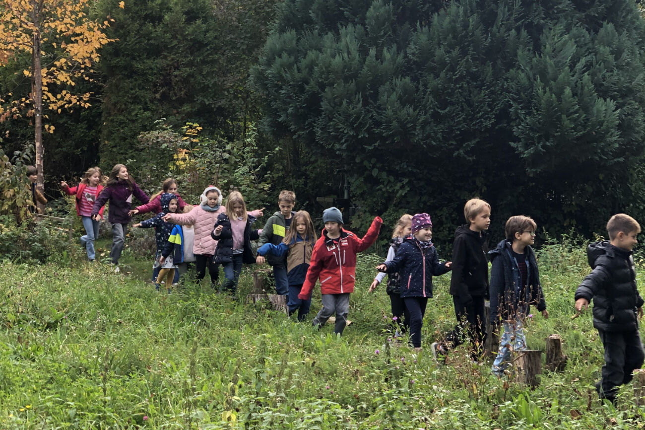 Im Gänsemarsch geht's für die Kinder auf einem Pfad quer durch eine Wiese.