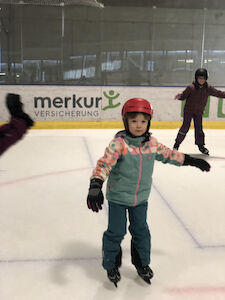 Zwei Kinder fahren vorsichtig am Eis.