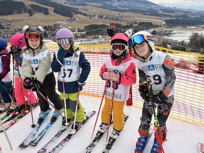 Fünf Kinder vor dem Start in voller Skifahrer*innen-Montur.