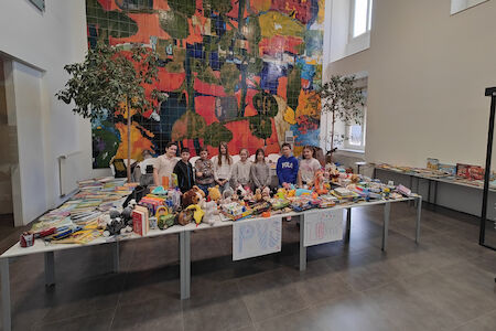 Die Schulrätin*innen kurz vor dem Flohmarkt-Verkaufbeginn hinter den Tischen mit vielen Spielen, Kuscheltieren etc.