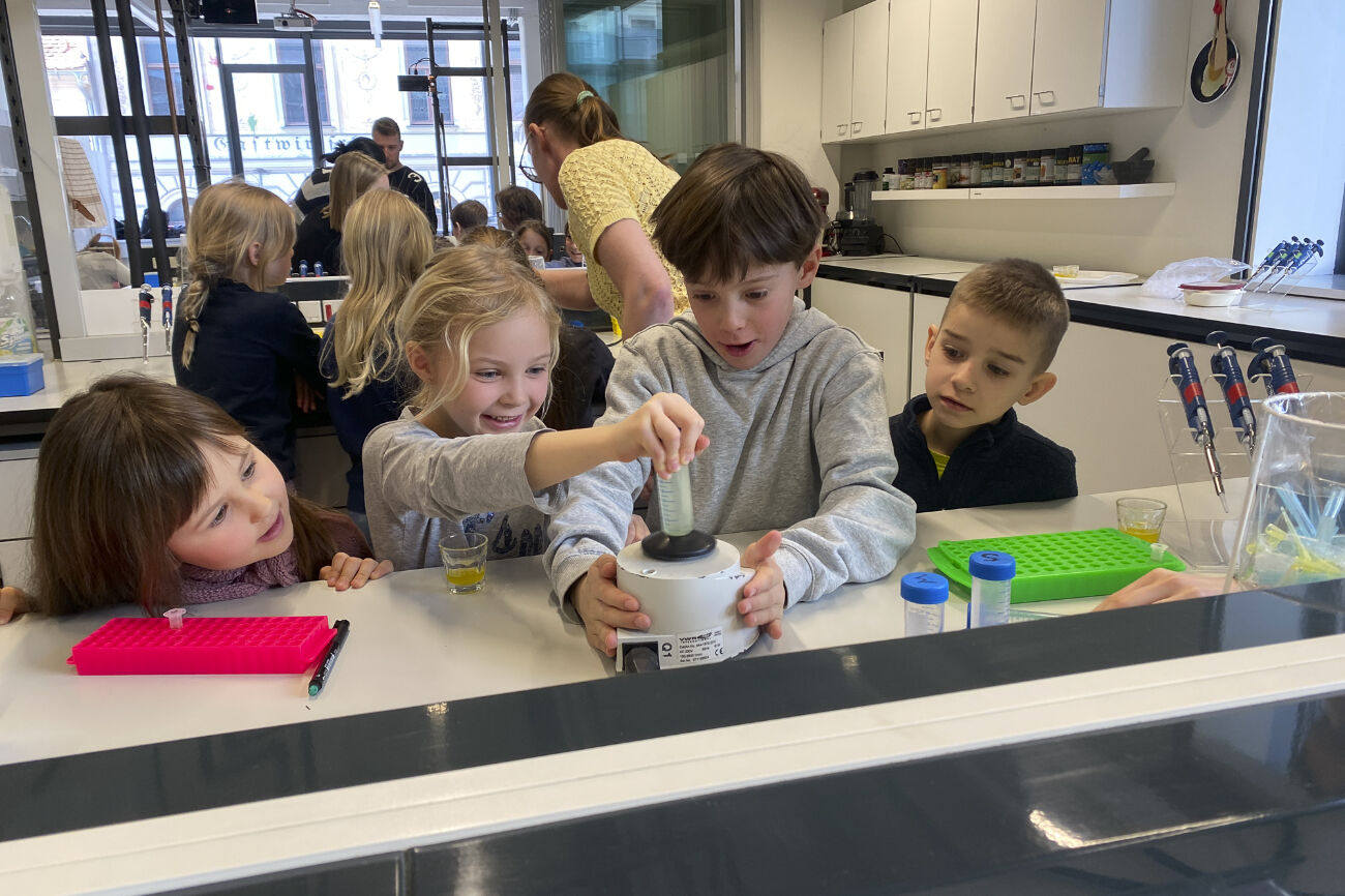 Vier Kinder experimentieren mit großer Freude an der Universität.