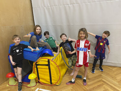 Stolz wird von Buben ihre Hütte präsentiert, die sich in einem Turnsaaleck verbindet.