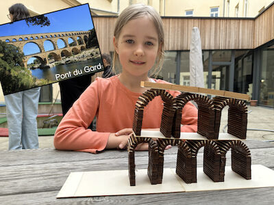 Ein Mädchen präsentiert das Aquädukt "Pont du Gard" in Miniaturform, welches in Kleinarbeit hergestellt wurde.