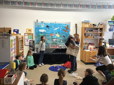 Im Workshop 4 (Meeresbewohner) wird fleißig Theater gespielt! Im Hintergrund ist ein schön gestaltetes Plakat vom Leben im Meer zu sehen.
