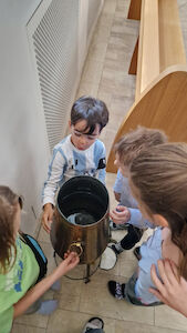 In der Kirche Augustinum wird das Weihwasser von den Kindern näher inspiziert.