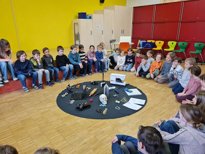 Der Beginn der Themenarbeit "Berufe" im kleinen Festsaal mit allen Kindern und einer schön gestalteten Mitte.