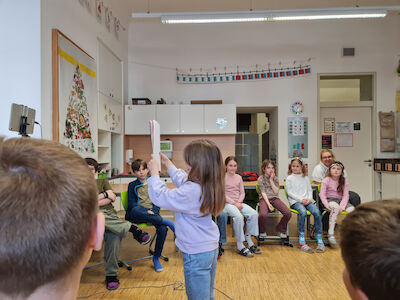 Die Kinder lauschen interessiert der Präsentation einer Mitschülerin.
