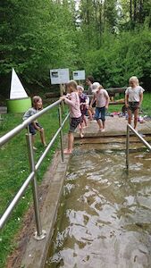 Einige Kinder versuchen sich im Kneippend, wo sie mit den Beinen durchs kalte Wasser gehen.