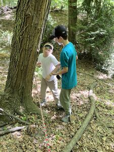 Zwei Kinder erkunden den Wald mit allen Sinnen.
