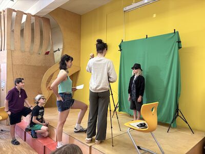 Vor einem grünen Tuch wird die Greenscreen-Technik den Kindern nähergebracht.