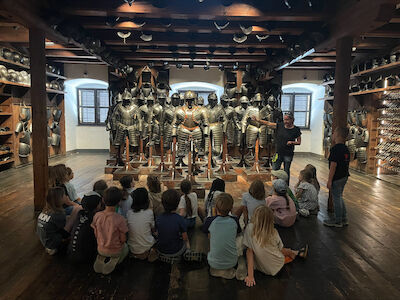 Die Kinder lauschen gespannt der Museumsführerin beim Erklären all der Rüstungsdetails zu.