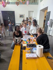 Kinder stellen sich beim Kinderschminken an.