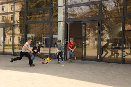 Buben spielen am Vorplatz der Sporthalle Floorball.