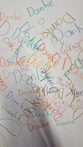 Ein Blatt mit vielen bunten "Danke"-Wörtern von Kindern geschrieben.