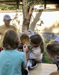 Frischer Saft wird mit einer Saftpresse von mehreren Kindern hergestellt.